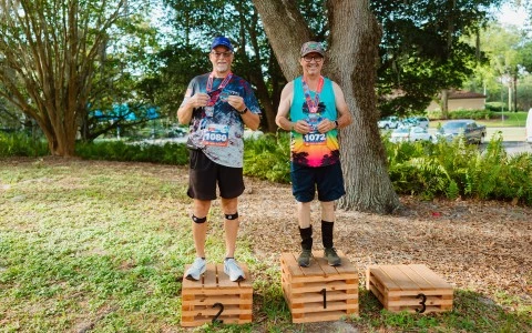 two men standing on wooden crates with numbers on them