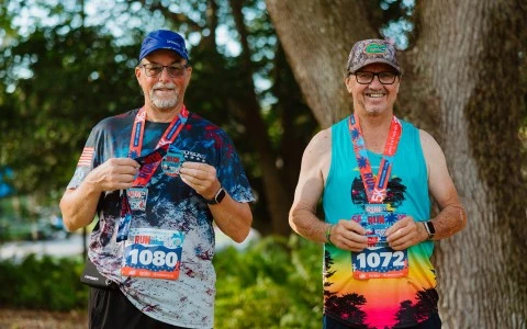 two men wearing medals and running
