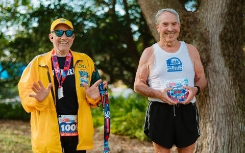 two men wearing medals and running gear