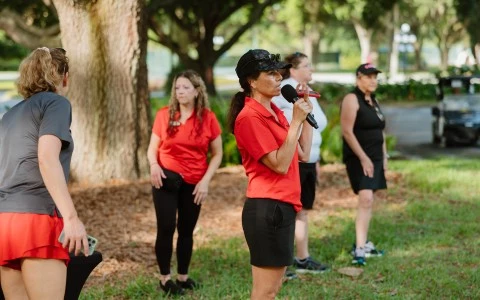 a woman holding a microphone in front of a group of people