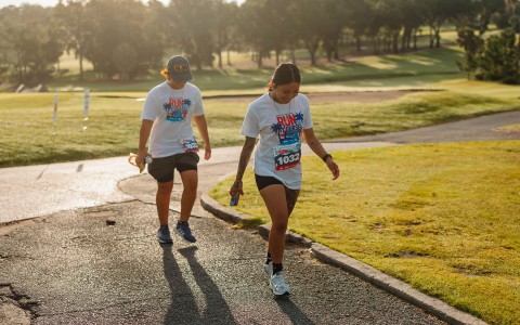 a couple of women running in a park