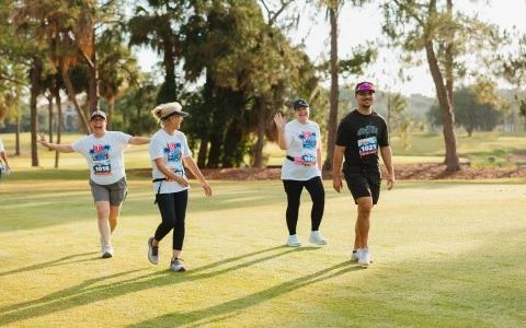 a group of people running on a grass field