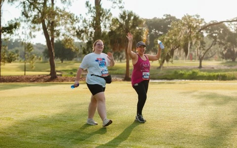 two women running on a grass field