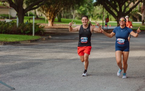 a man and woman running in a park