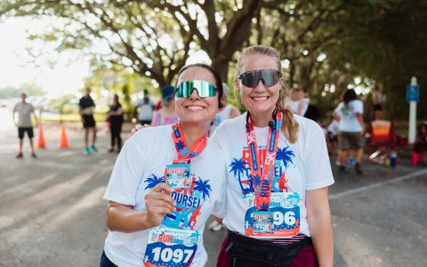 two women wearing matching shirts and matching necklaces
