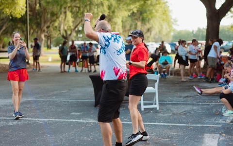 a man and woman dancing in a parking lot
