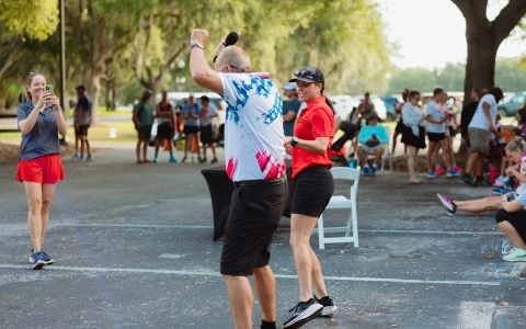 a man and woman dancing in a parking lot
