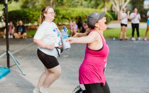 a woman running with a bottle of water and another woman running