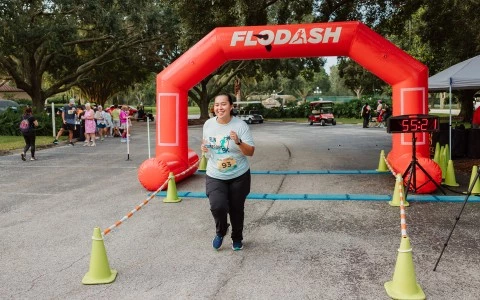 a woman running under an inflatable arch