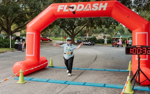 a woman running under an inflatable arch