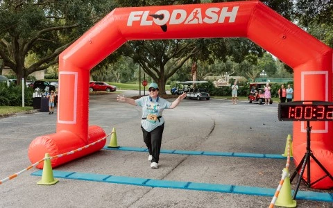 a woman running under an inflatable arch