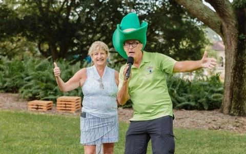 a man and woman in a green hat holding a microphone