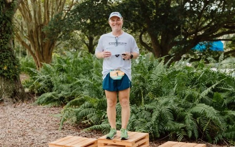 a man standing on a wooden platform with a number on it