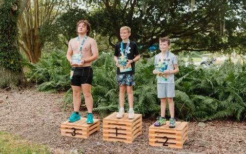a group of boys standing on wooden crates with medals around them