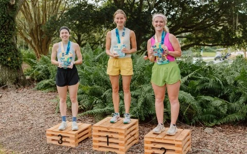 a group of women standing on wooden boxes with medals