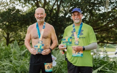 two men wearing medals and standing in front of trees
