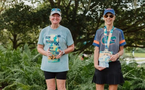 two women wearing medals and standing next to each other