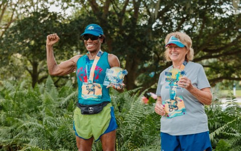 a man and woman wearing medals and holding medals