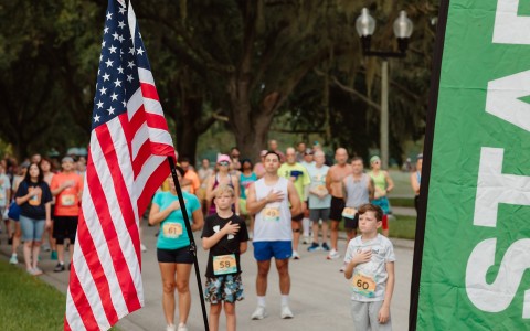 a group of people standing in a line with a flag