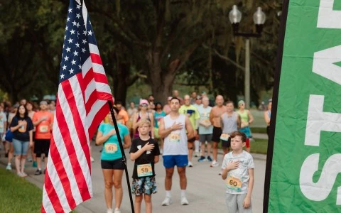 a group of people standing in a line with a flag