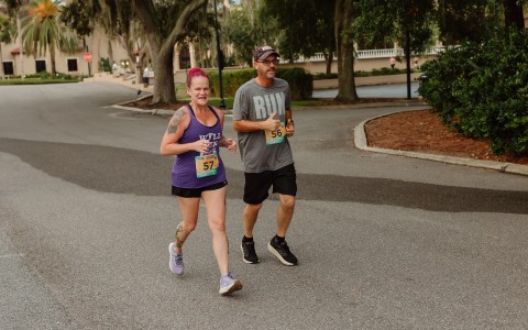 a man and woman running on a road