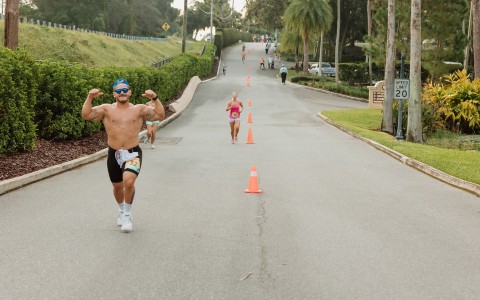 a man running on a road with orange cones