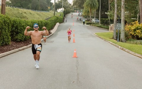 a man running on a road with orange cones