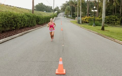 a woman running on a road with orange cones