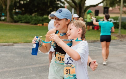 a woman and child holding a medal