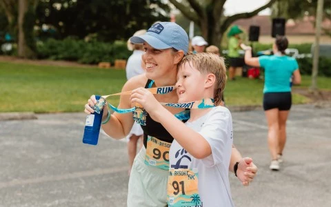 a woman and child holding a medal