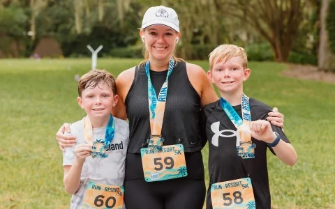 a woman and two boys wearing medals