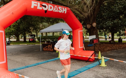 a woman running under an inflatable arch