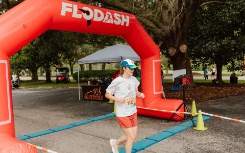 a woman running under an inflatable arch