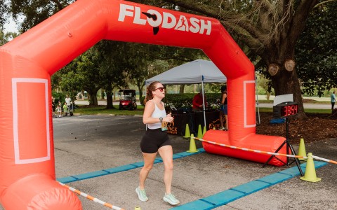 a woman running under an inflatable arch