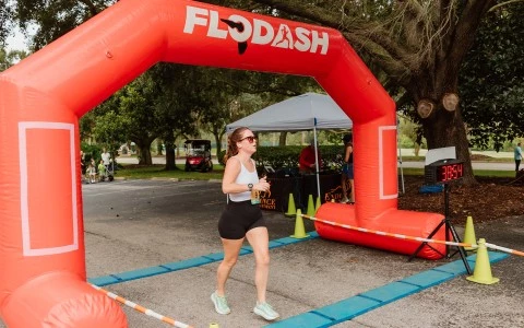 a woman running under an inflatable arch