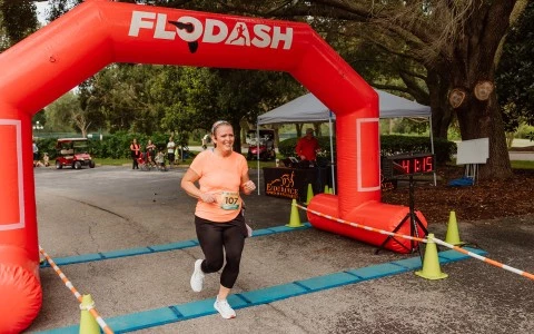 a woman running under an inflatable arch