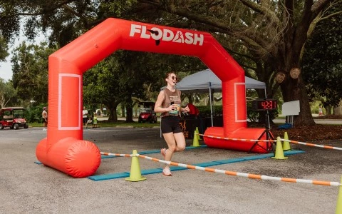 a woman running under an inflatable arch