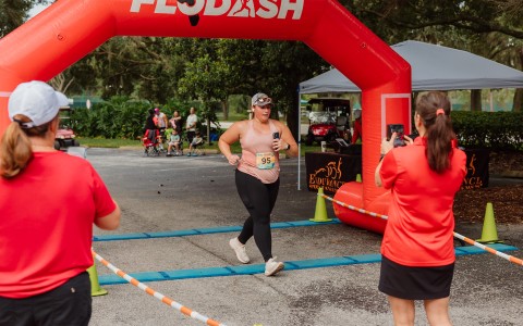 a woman running under an inflatable arch