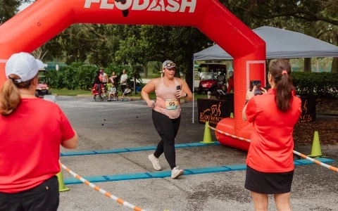 a woman running under an inflatable arch