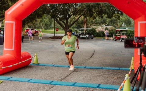 a woman running under an inflatable arch