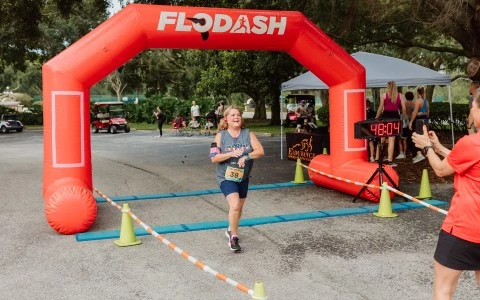 a woman running under an inflatable arch