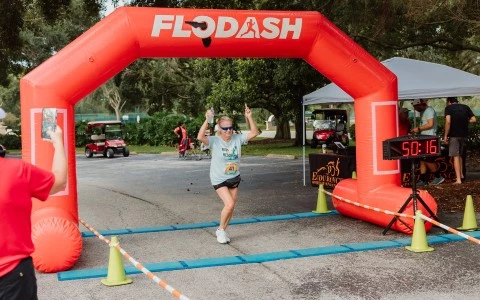 a woman running under an inflatable arch