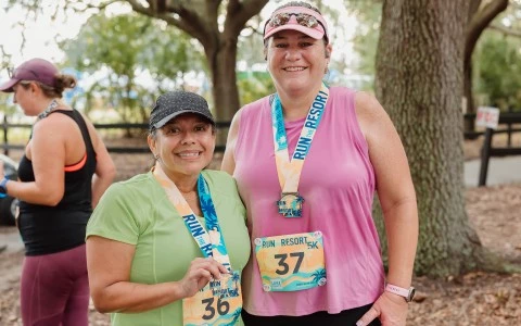 two women wearing medals around each other