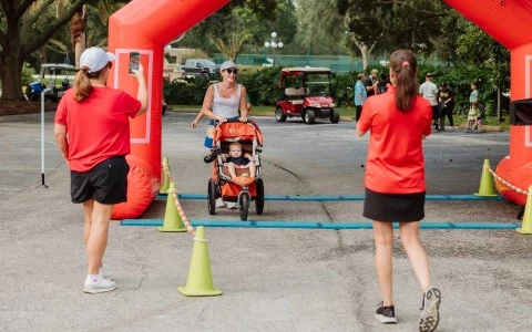 a woman pushing a stroller with a child in a red archway