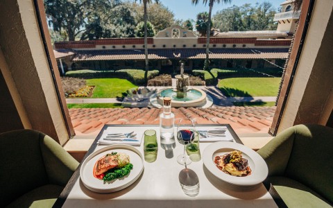 a table with plates of food and wine glasses on it