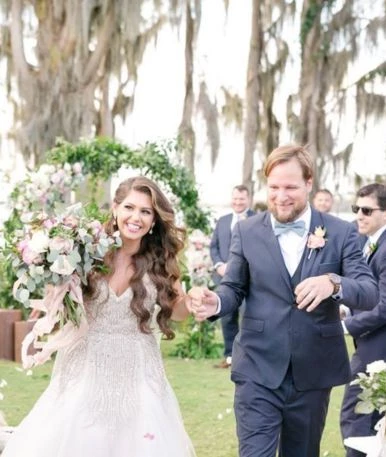 a man and woman walking down a lawn