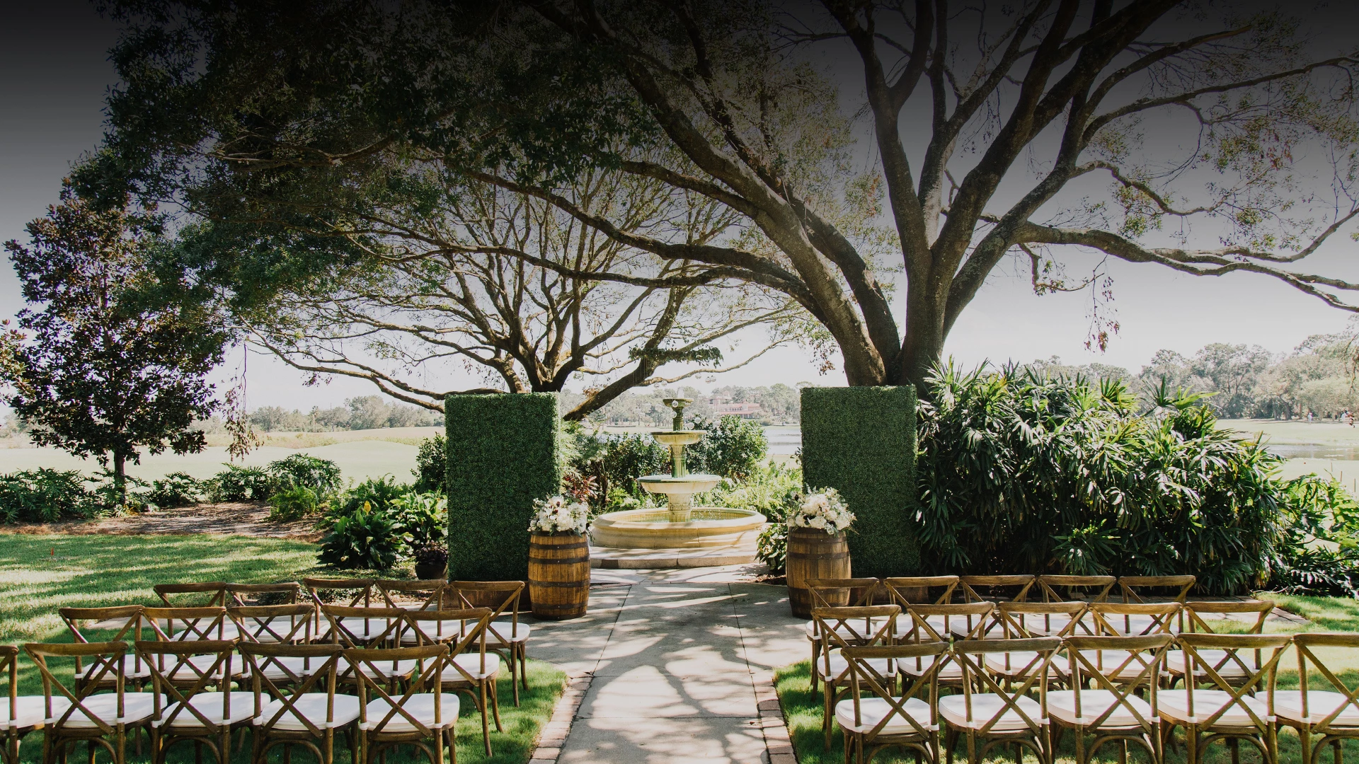 a fountain and chairs under a tree