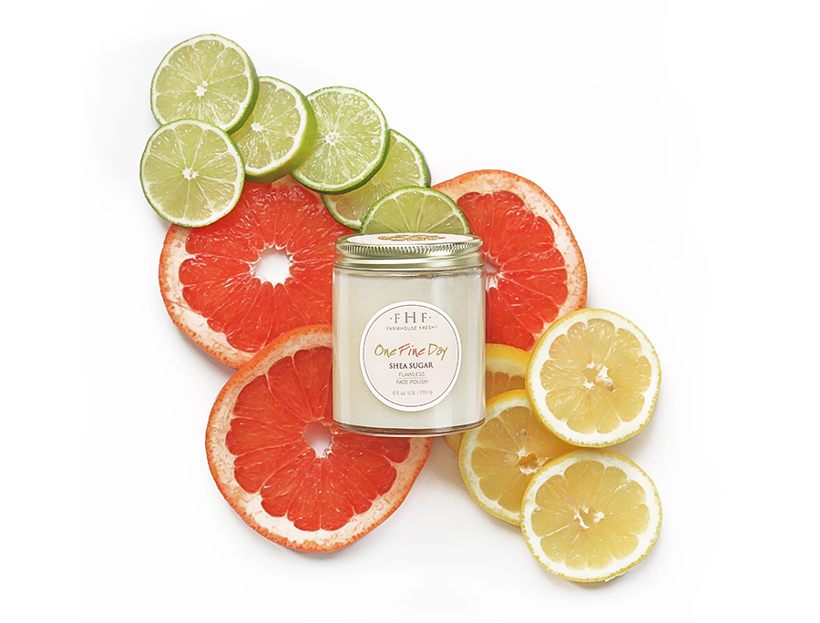 a jar of candle surrounded by sliced citrus fruits