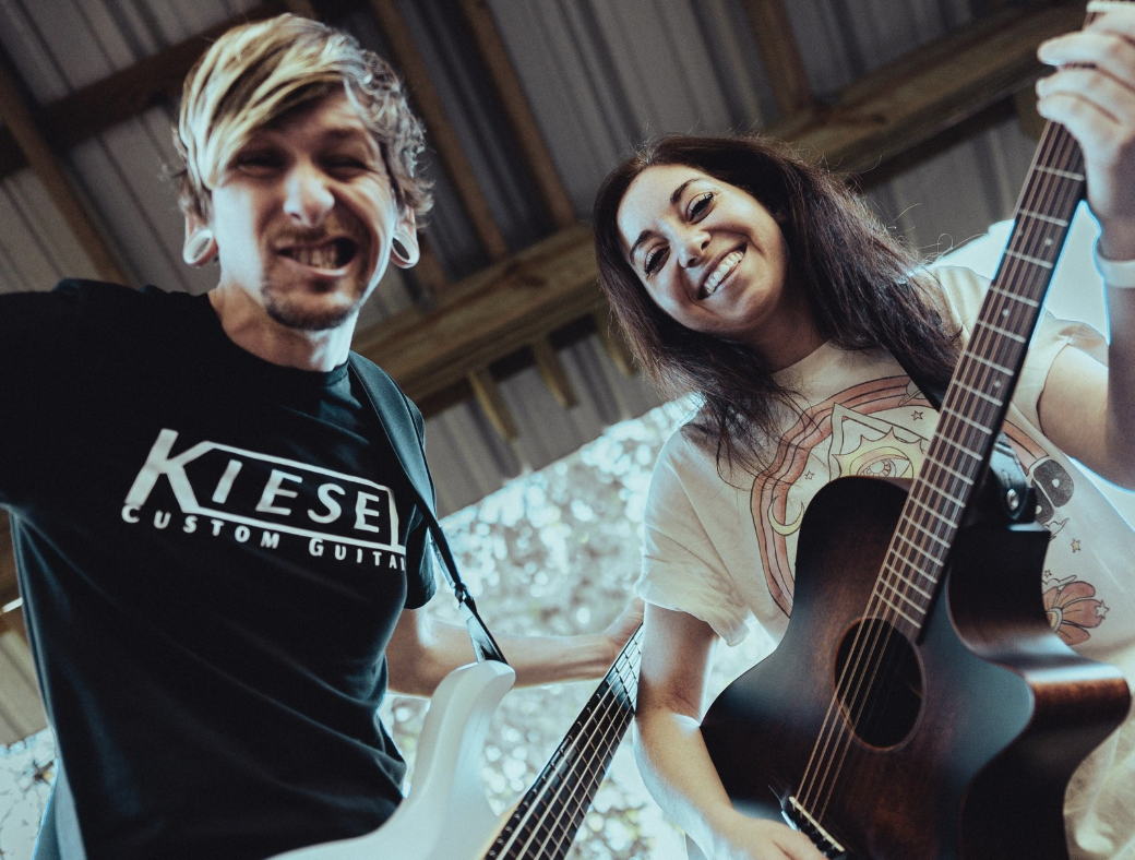 a man and woman playing guitars