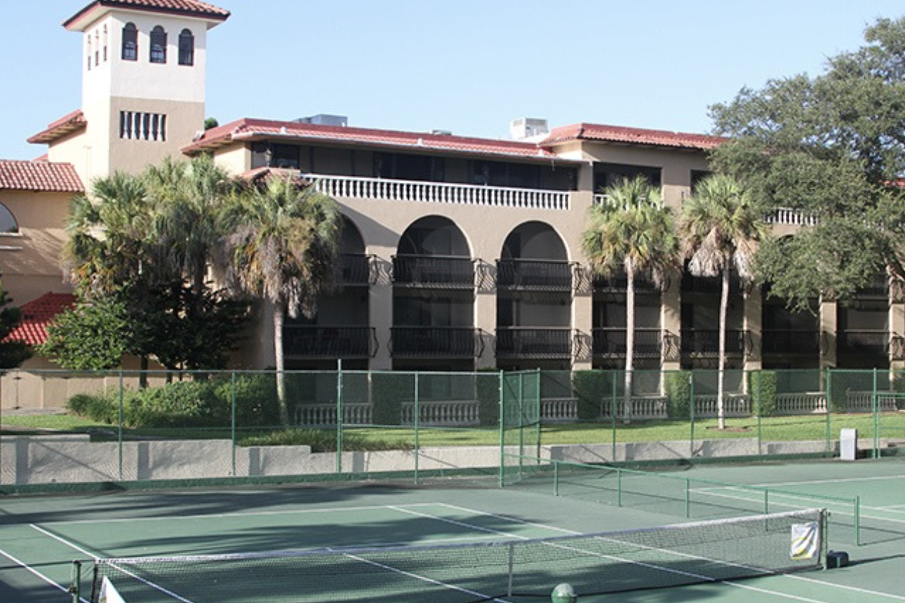 a tennis court with palm trees